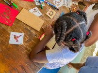 A young girl decorating her pouch using bird stencils during the Endemic Animal Festival.