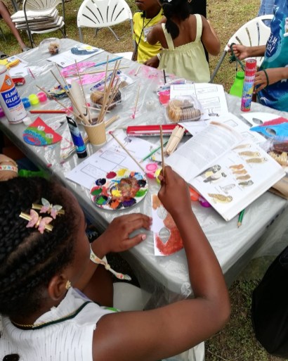 A child paints a bird mask.