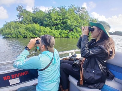 People on a boat looking through binoculars